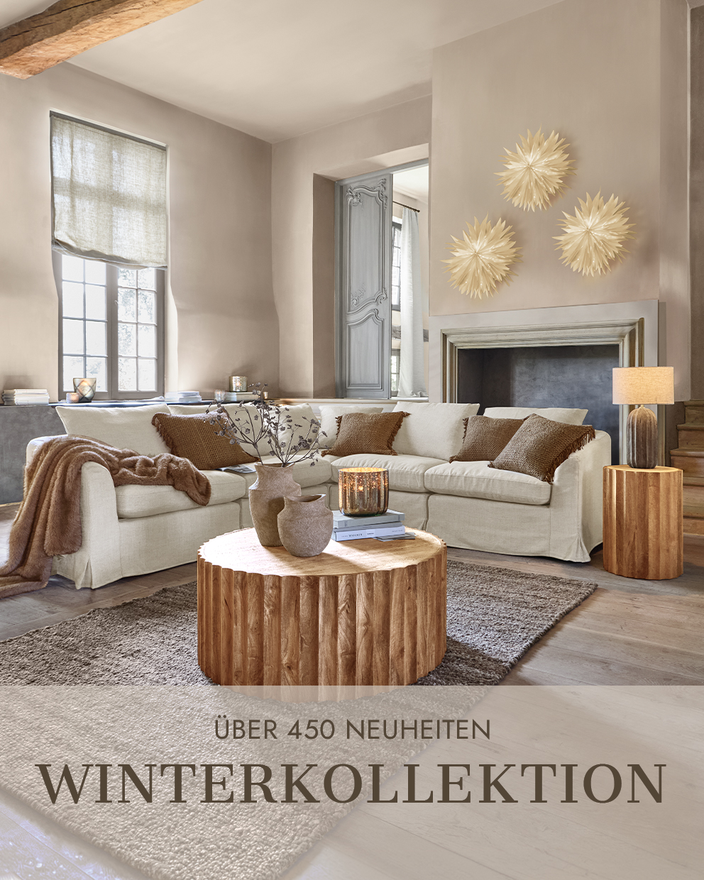 Gemütliches Wohnzimmer mit beigem Sofa, Holztisch und Wanddekorationen aus der Winterkollektion