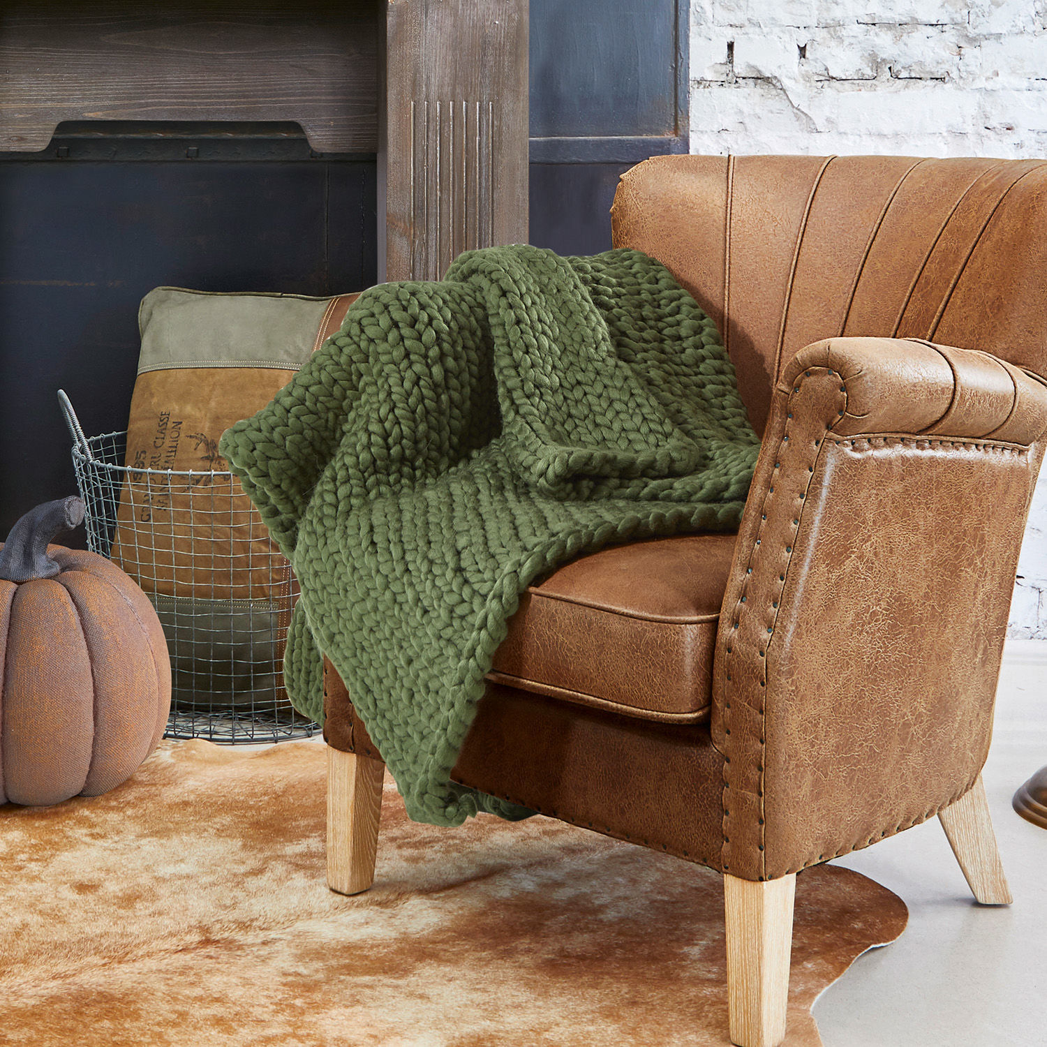 Plaid Reidous Brauner Kunstleder-Sessel mit grünem, grob gestricktem Plaid auf hellem Vintage-Teppich