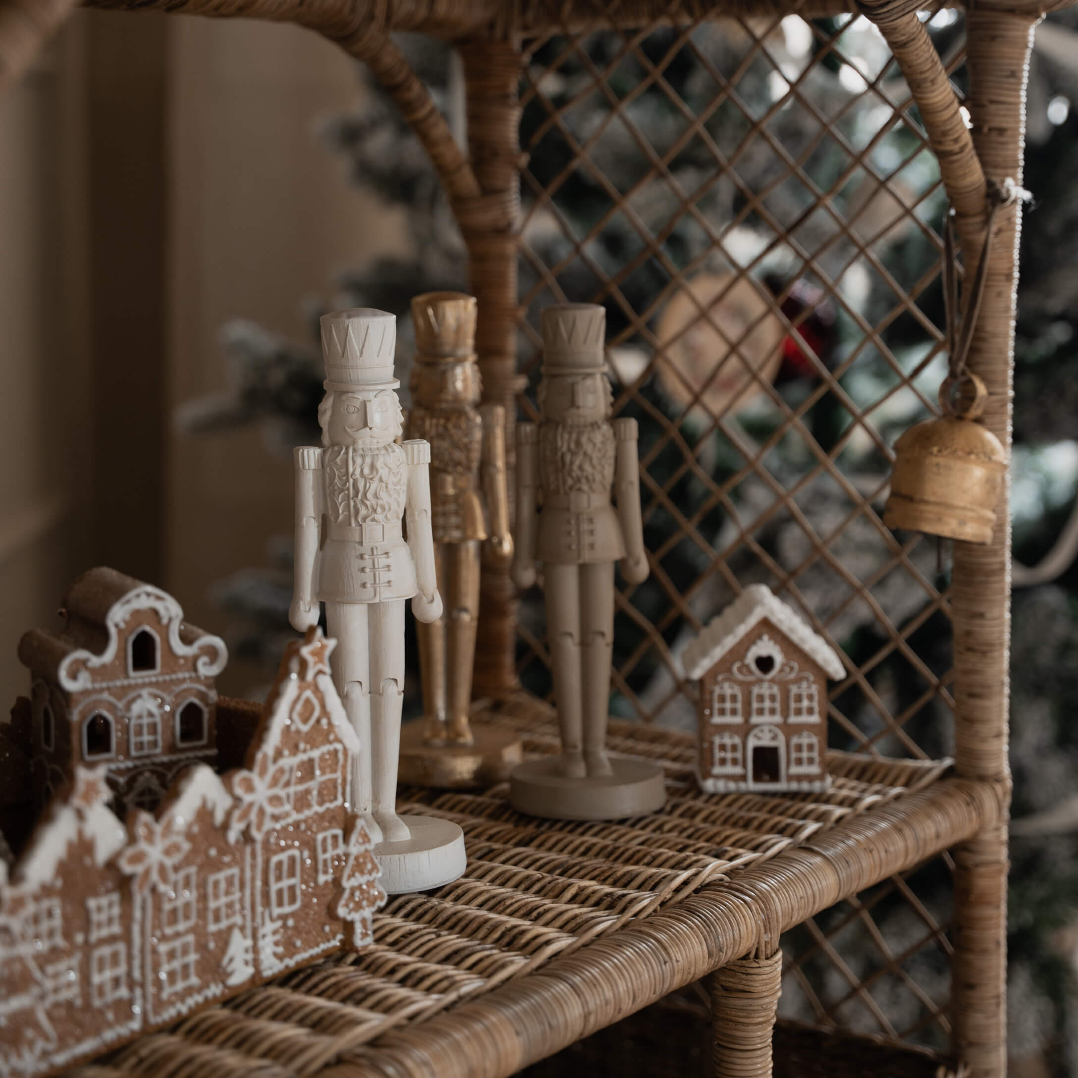 Holz-Nussknacker in Weiß und Beige auf einem Rattanstuhl mit Lebkuchenhäusern dekoriert