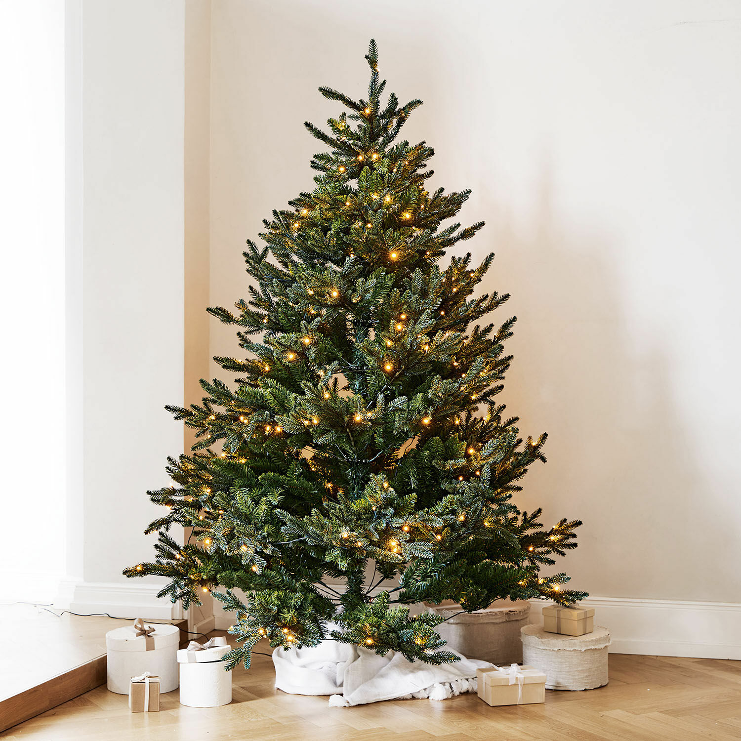 Weihnachtsbaum Franck Künstlicher grüner Weihnachtsbaum mit warmweißen LED-Lichtern auf Holzboden mit Geschenken
