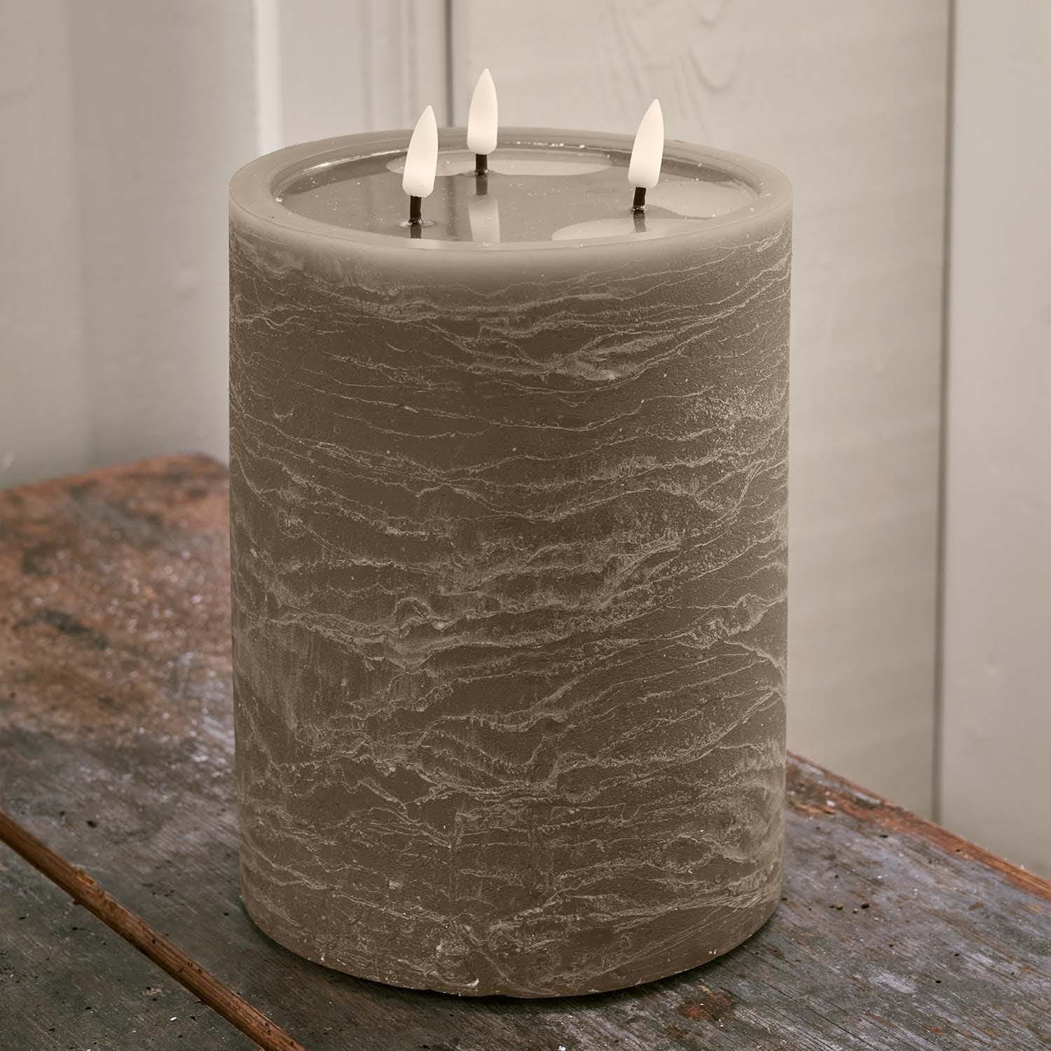 Große graue Kerze mit drei Dochten auf Holztisch, Wohnaccessoire und Lichtquelle