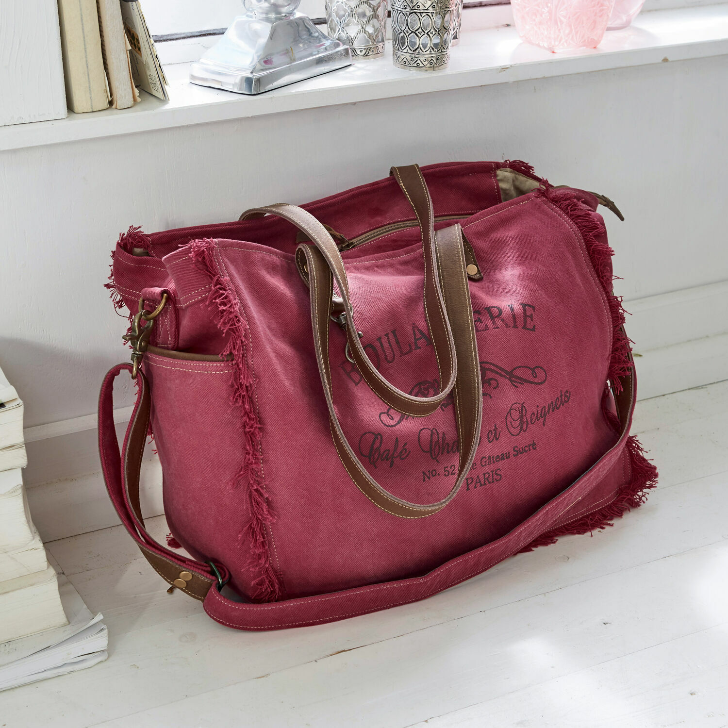 Tasche Anoush Reisetasche aus rotem Canvas mit braunen Griffen und Vintage-Aufdruck auf weißem Boden