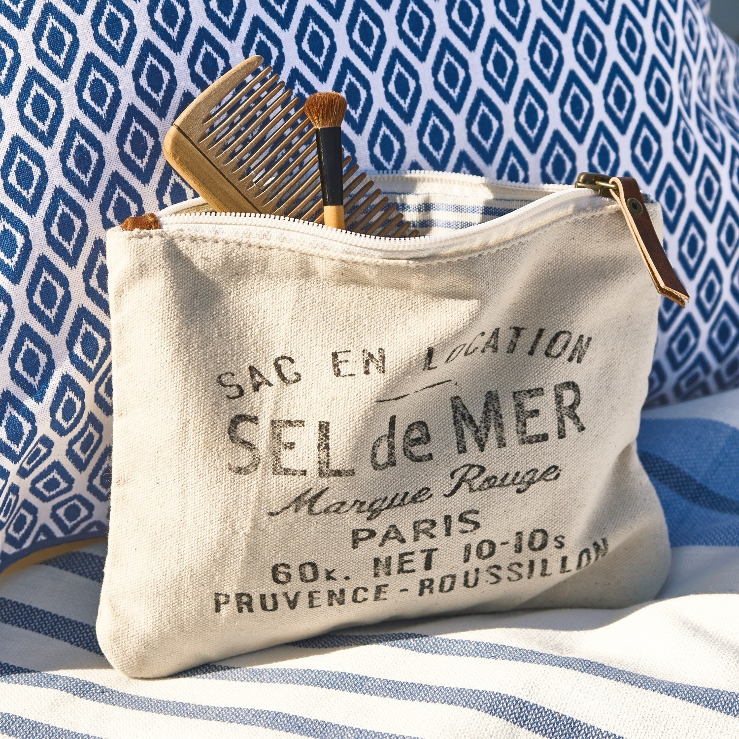 Täschchen Sel de Mer Beige Baumwoll-Kosmetiktasche mit Aufdruck und Lederreißverschluss vor blau-weißem Stoff
