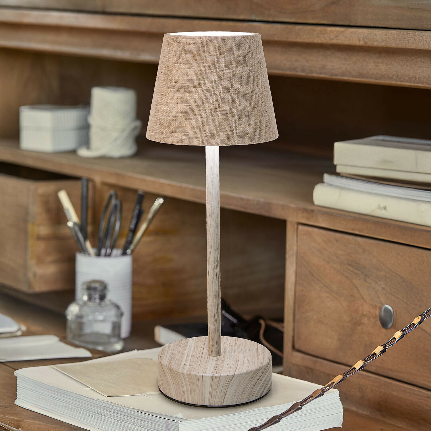 Wiederaufladbare Tischlampe Sylvainie Tischlampe mit beigem Stoffschirm und Holzfuß auf Schreibtisch mit Büchern und Schreibutensilien