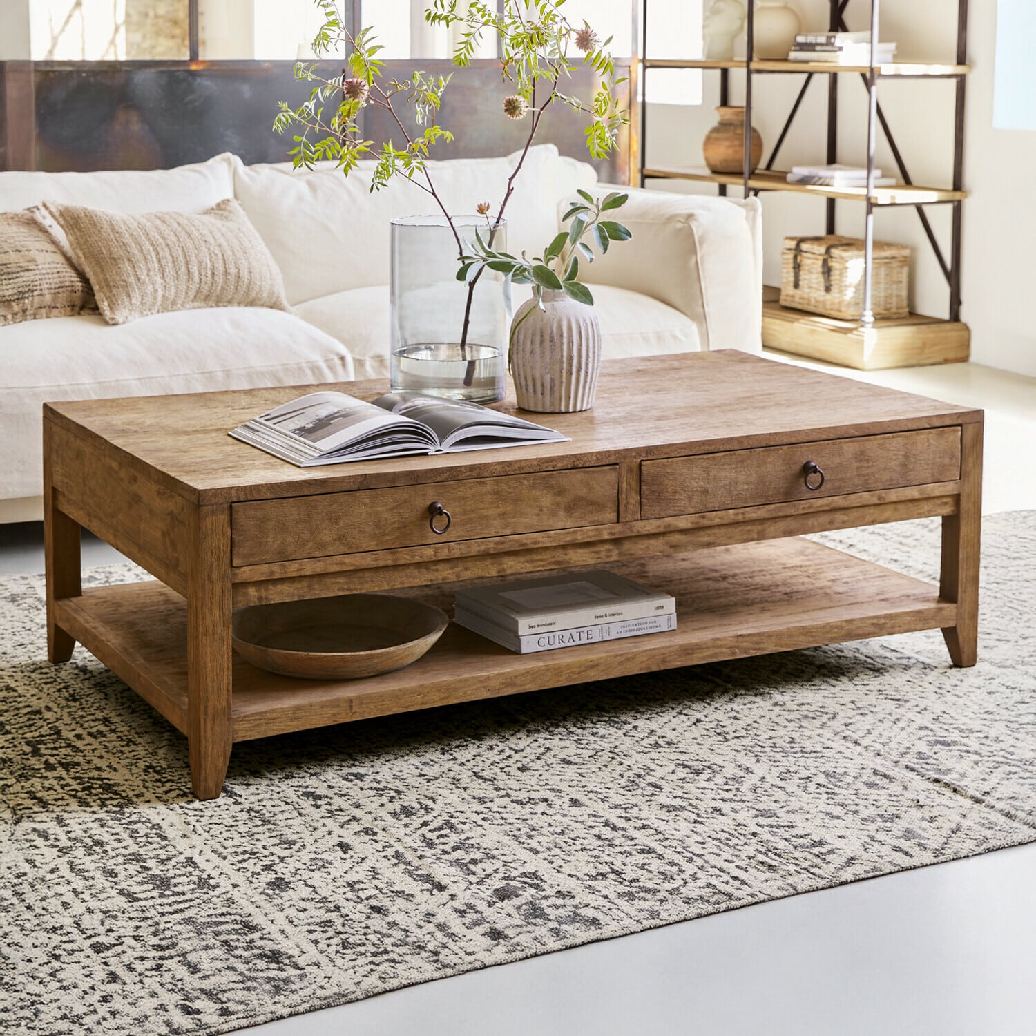 Couchtisch Rasmus Holz-Couchtisch in Naturfarbe mit Schubladen und Ablagefläche auf gemustertem Teppich