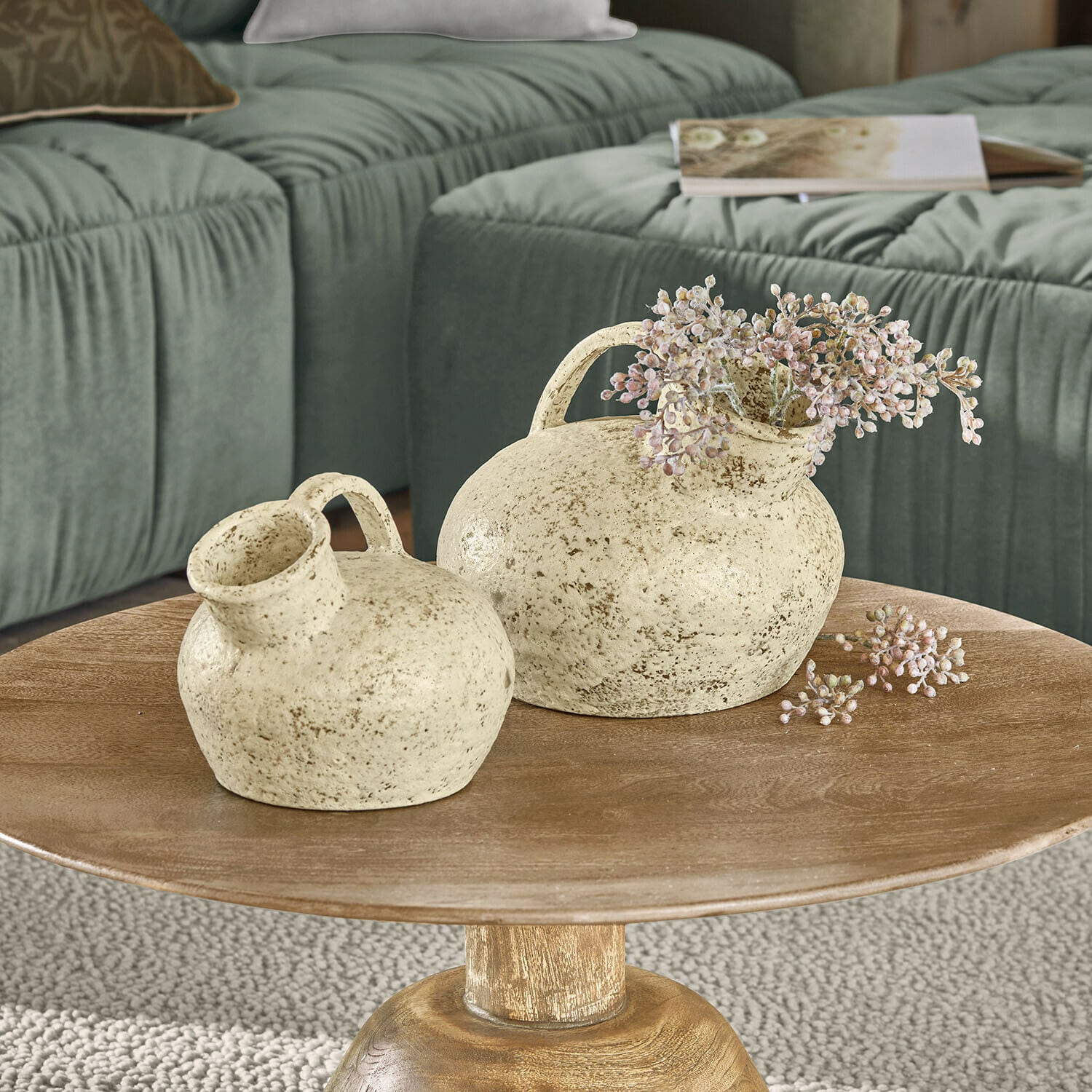 Vase 2er Set Gravière Zwei cremefarbene Keramikvasen mit Griffen auf einem Holztisch vor grünem Sofa im Wohnzimmer