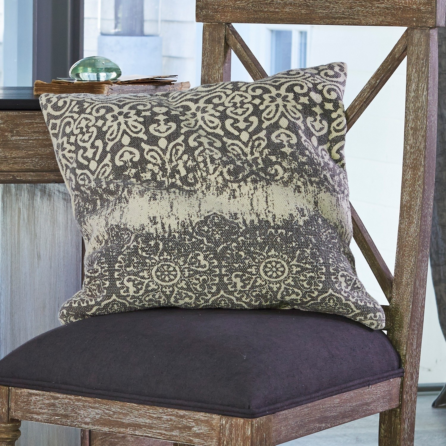 Kissen Demian Dekoratives Baumwollkissen in Grau-Beige mit Muster auf Holzstuhl im Wohnzimmer