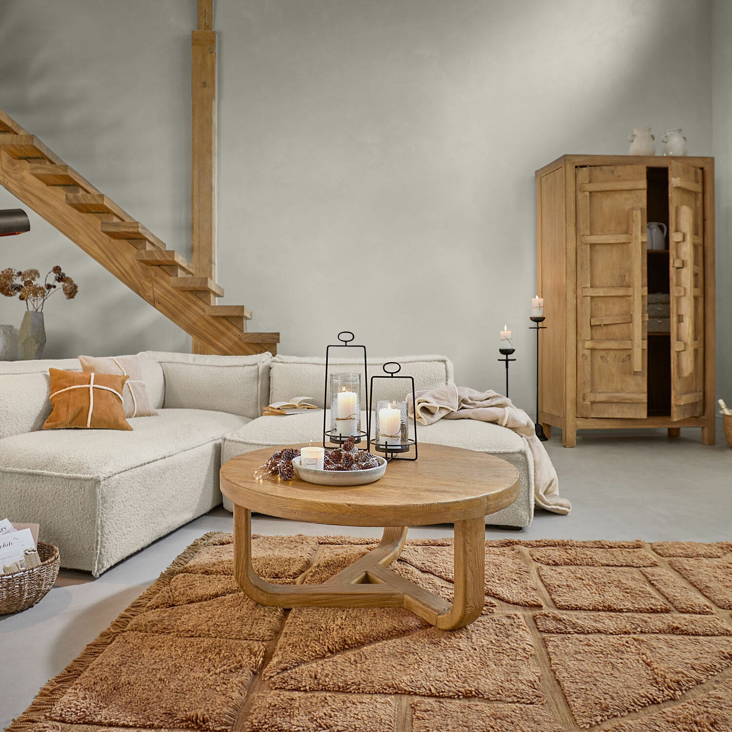 Teppich Volemar Wohnzimmer mit beigem Sofa, runden Holztisch und warmbraunem Teppich, modernes Interieur mit Naturmaterialien