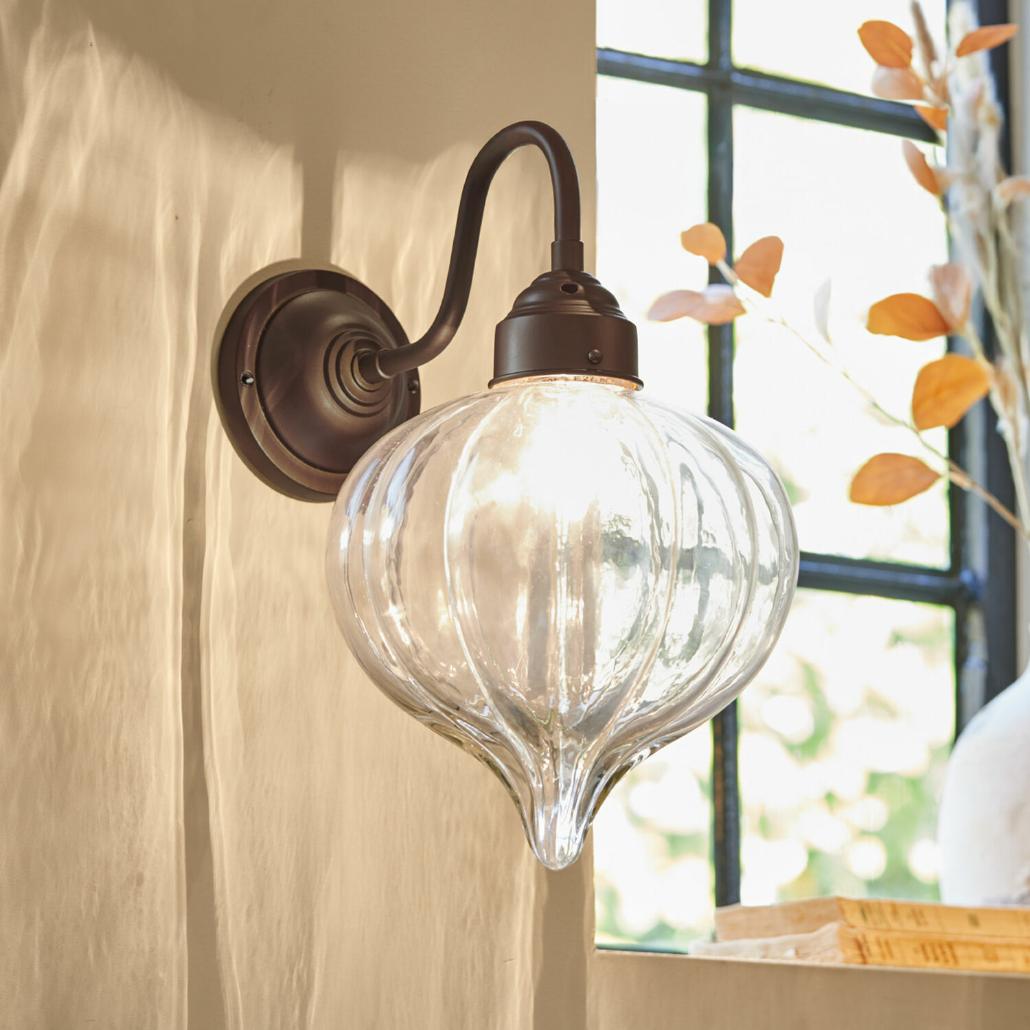 Wandlampe Baisse Wandleuchte aus klarem Glas mit braunem Metallhalter für stilvolle Innenraumbeleuchtung