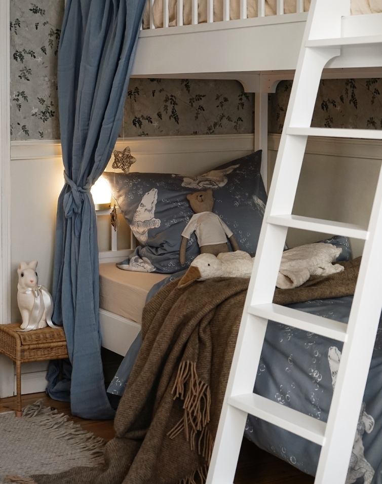 Gemütliches Etagenbett mit blauer Tiermuster-Bettwäsche und brauner Decke im Kinderzimmer